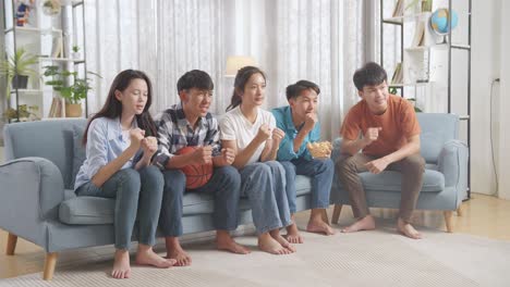 아시아 십대 들 이 집 에서 tv 에서 농구 경기 를 지켜보고 응원 하고 있다