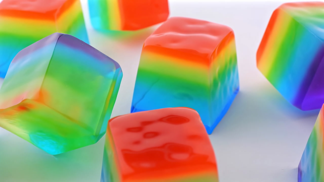 Rainbow Jelly Cubes On White Background, Glossy Layered Gelatin Candies Captured In Macro Studio Shot,