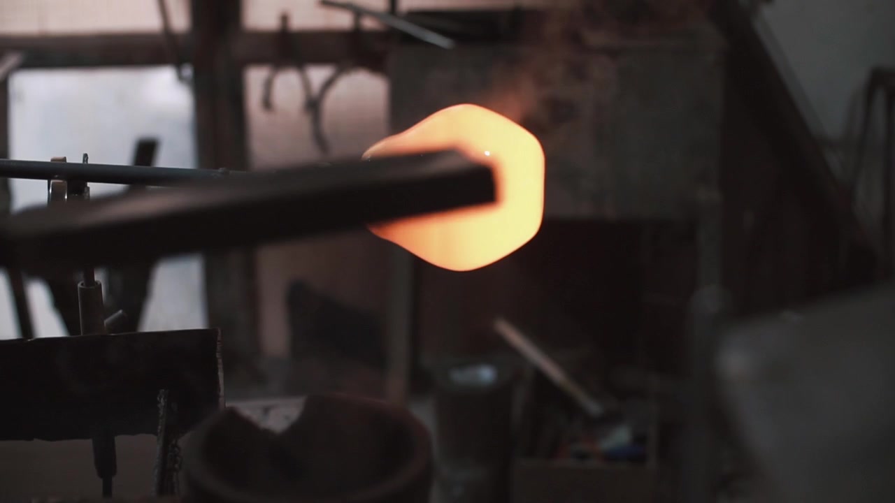Artisan Shaping Molten Glass in a Traditional Glassblowing Workshop