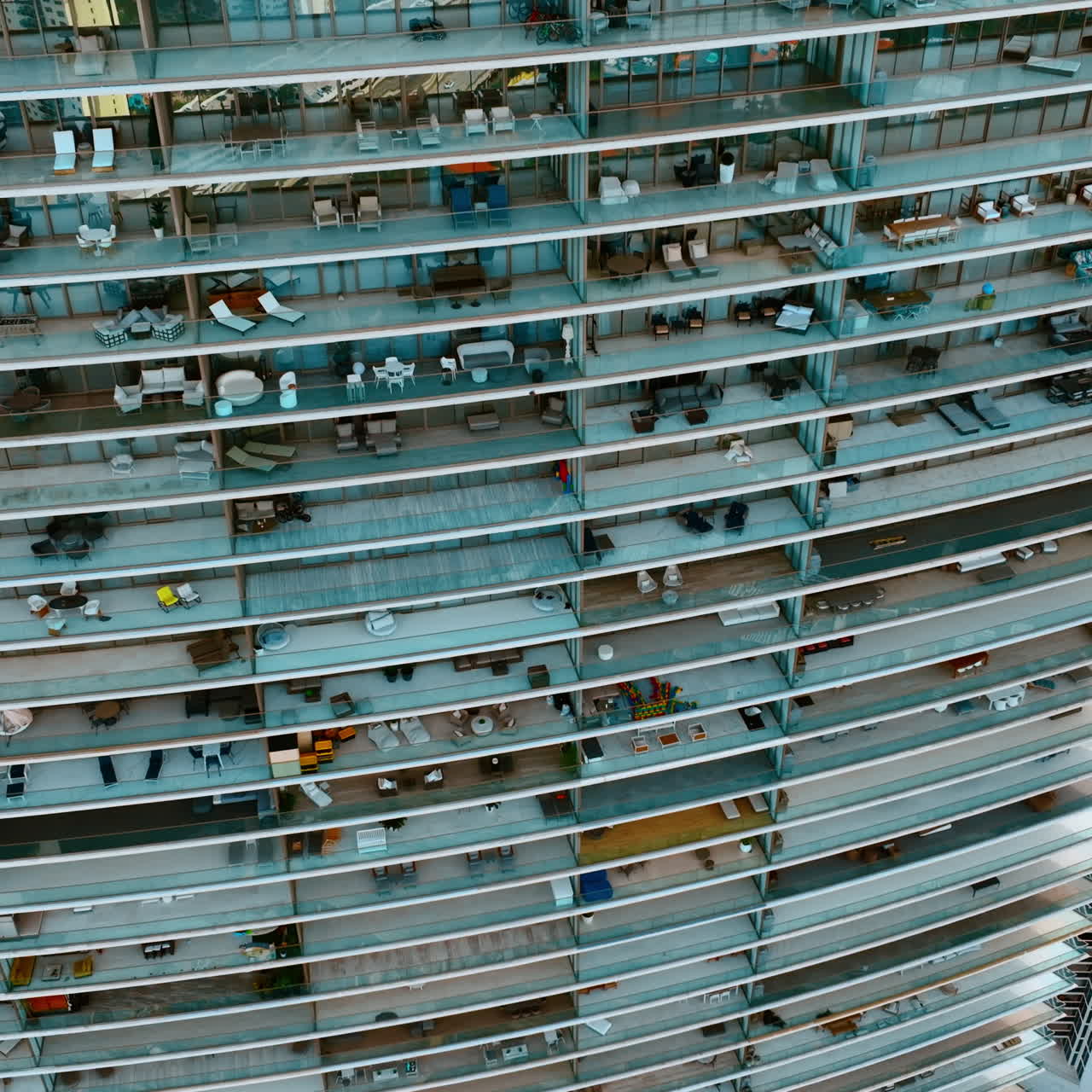 Descending along the huge residential block of flats with spacious balconies. Drone footage of a house in Miami. Top view.