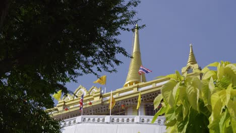 cinematic slow motion slider over golden mount in bangkok, thailand with waving flag