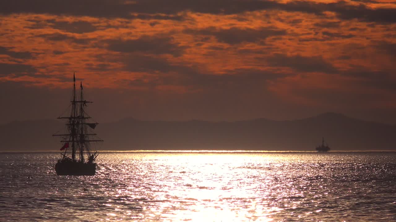 un barco de clipper alto navega al atardecer