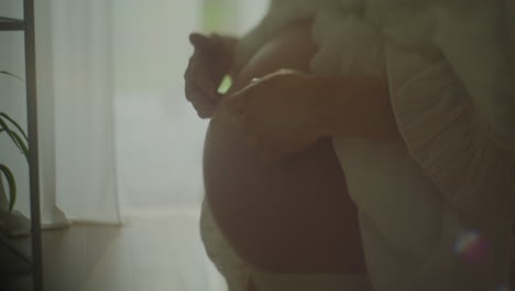 pregnant woman touching belly close-up