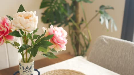 artificial peonies in a vase on a table