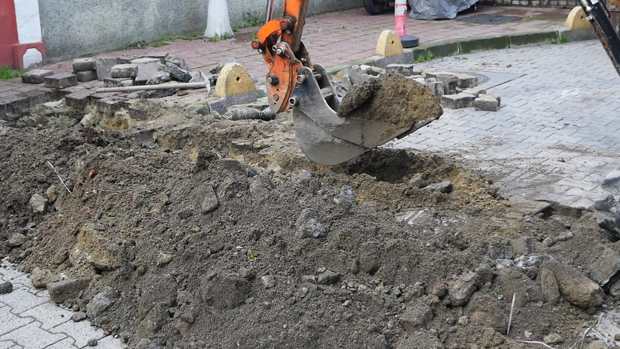 Excavator Bucket Digging and Moving Earth at Construction Site