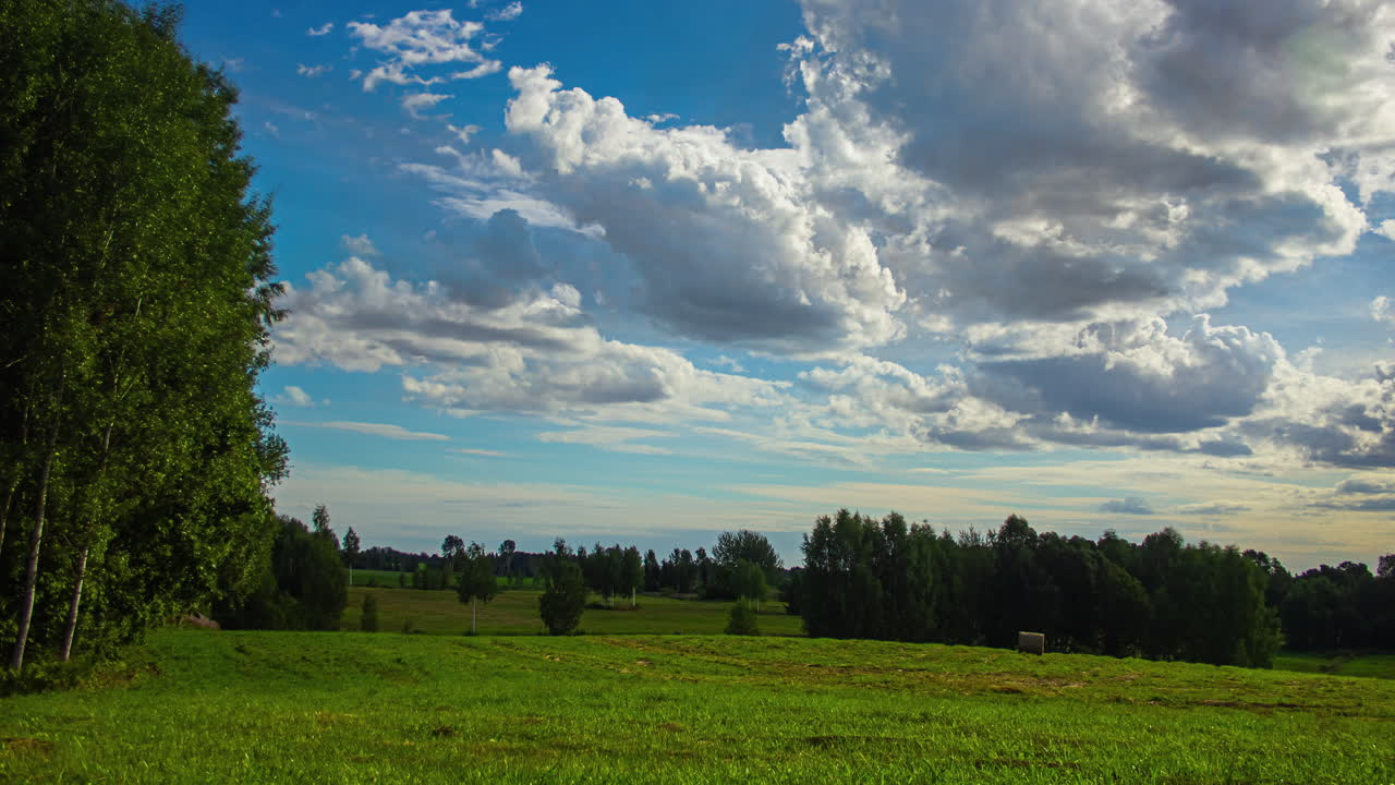 el lapso de tiempo de las nubes a la deriva sobre un paisaje verde y sereno, el sol desapareciendo de la pantalla