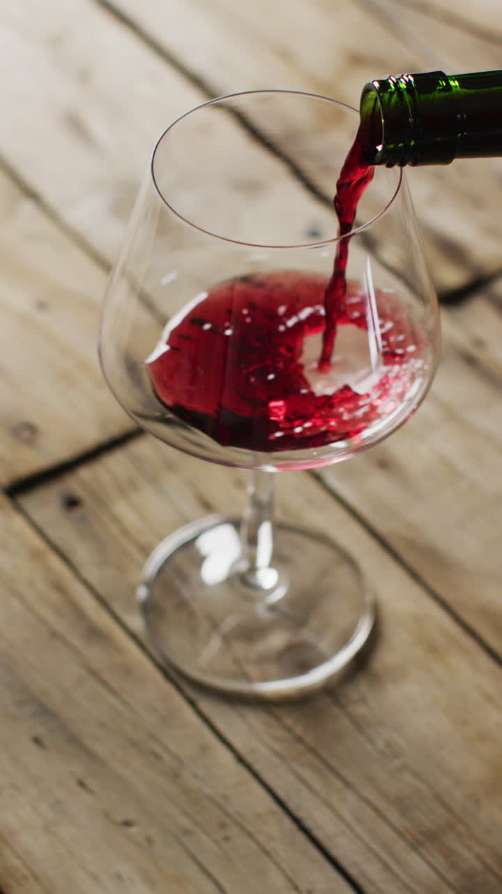 Video verticale di vino rosso che si versa in un bicchiere