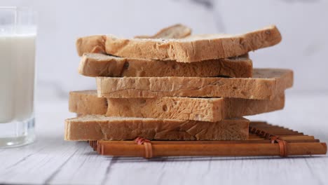 Stack-of-bread-and-glass-of-milk-on-table-,