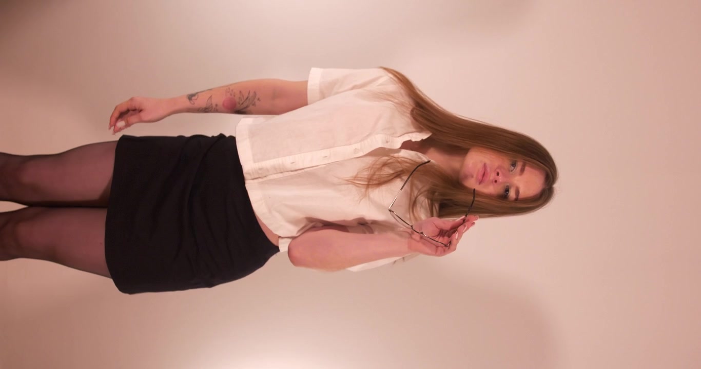 Bella ragazza che ammicca e guarda la fotocamera mentre si muove in modo seducente. Inquadratura verticale.
