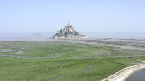 an establishing shoot of mont saint-michel - drone gaining altitude on a dull day