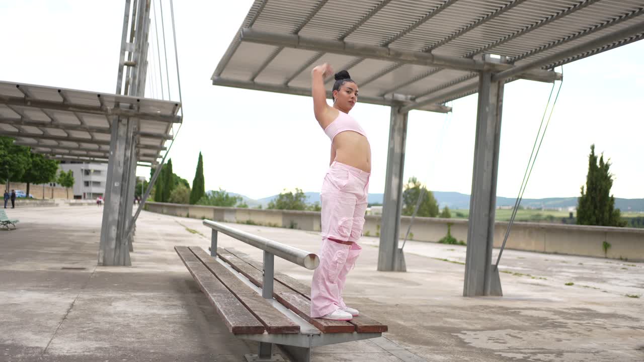 Woman in pink outfit exercising on a bench outdoors