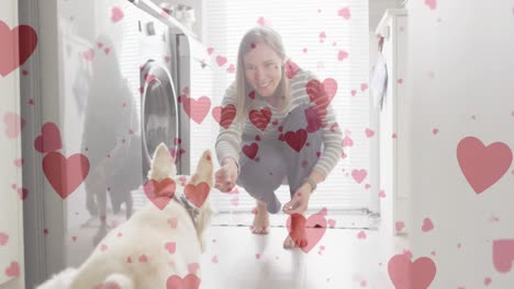 animation of heart emojis over happy caucasian woman with dog