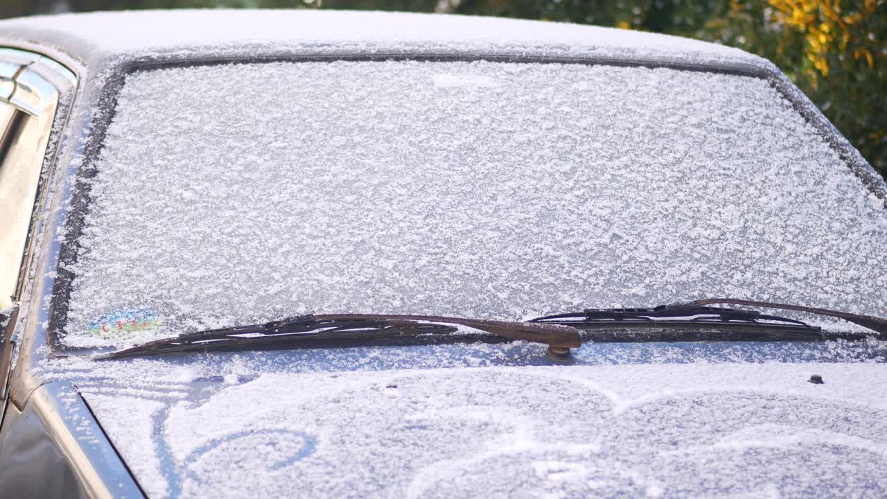 눈으로 인 앞 유리창이 있는 자동차