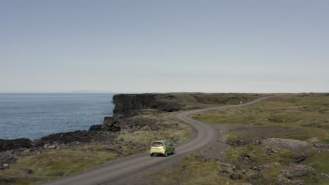 aerial of car traveling on rural road at volcanic coast of snæfellsnes peninsula