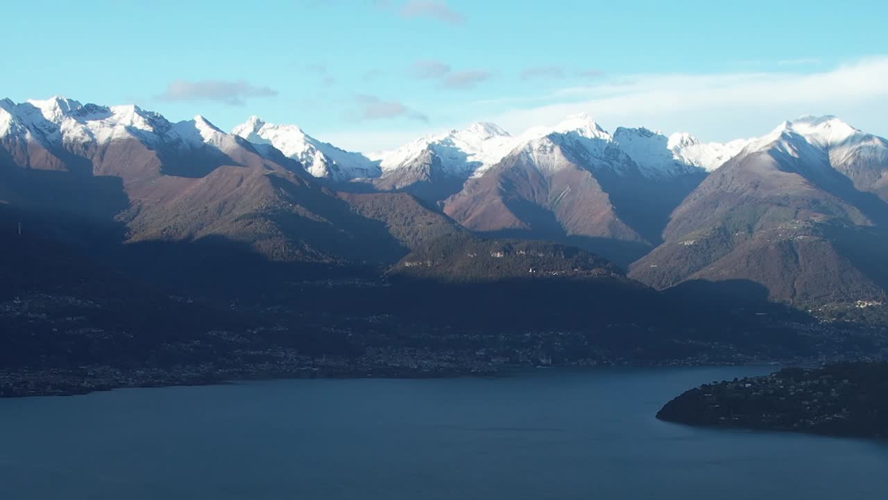 Breathtaking aerial view of snowy Alps mountains in Italy by the lake