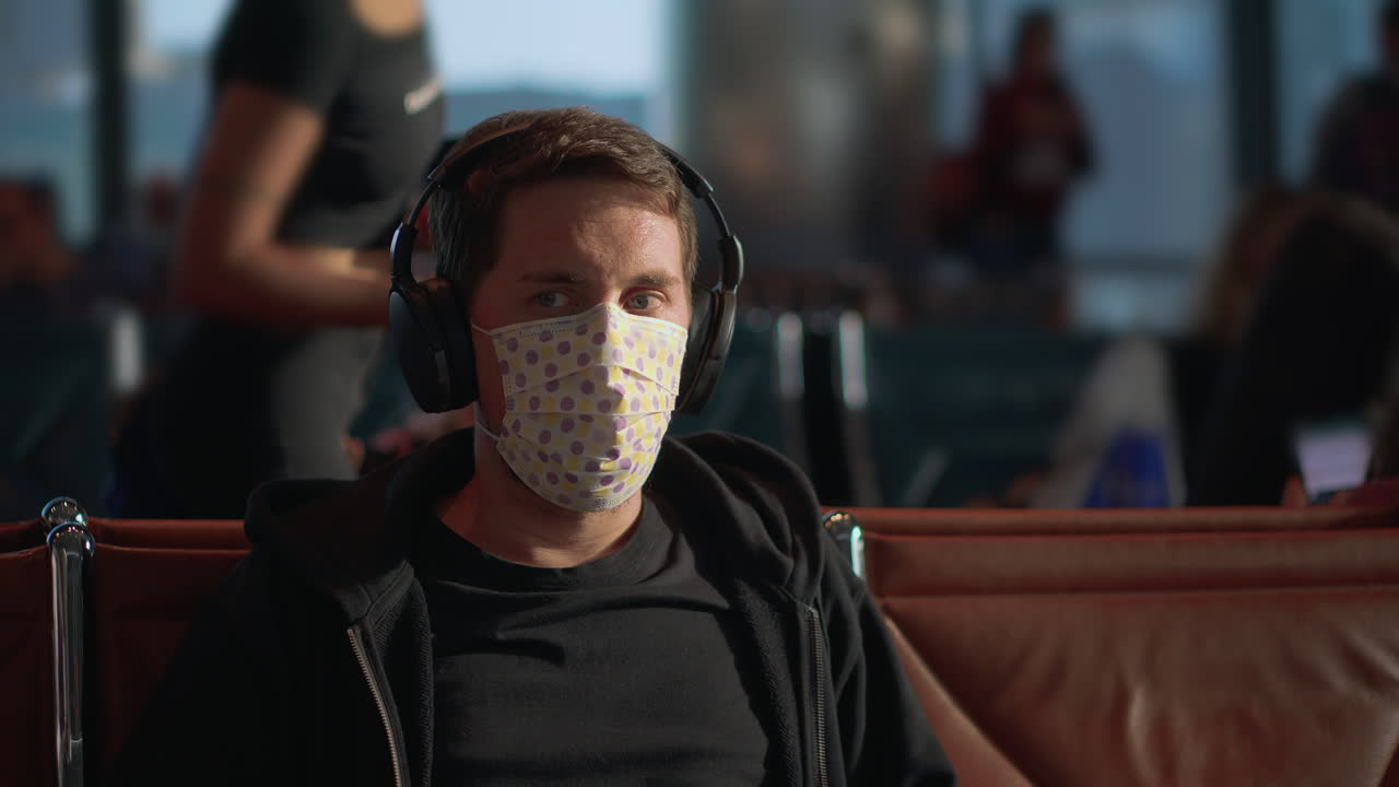 hombre con máscara y auriculares en el aeropuerto