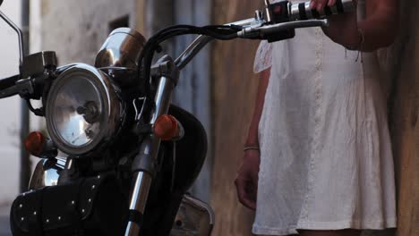 bella mujer con vestido blanco sosteniendo geniales manillares de motocicleta en cámara lenta filmada prores raw