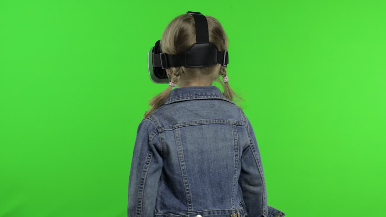 Bambina che usa un visore VR per app per giocare a un gioco di simulazione, disegnando. Guarda un video 3D di realtà virtuale.