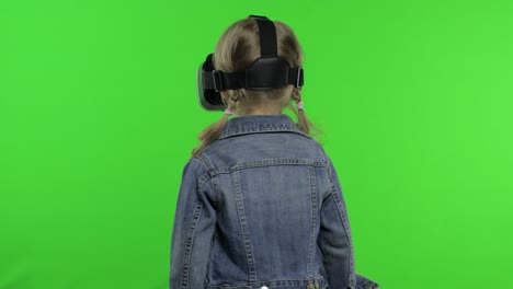 child girl using vr app helmet to play simulation game, drawing. watching virtual reality 3d video