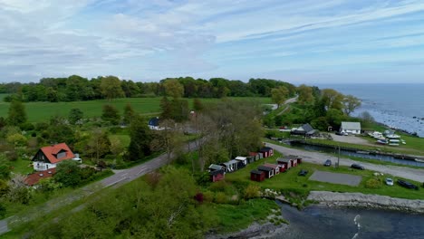 colorful house structures at the midst of green meadow and horte harbour in skane county, sweden