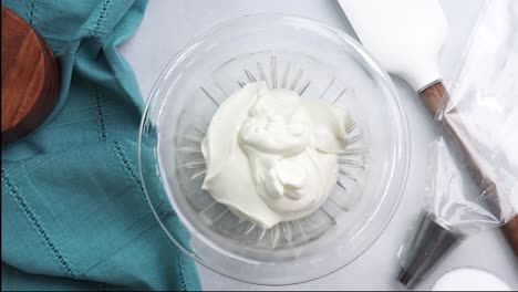 making a dessert called red raspberry tea cake made with fresh berries and vanilla buttercream frosting. great for tea parties. adding white sugar into the mixing bowl and combining the ingredients