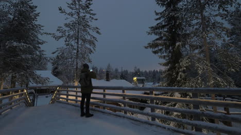 man making photos on winter resort in the evening