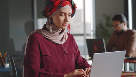 hermosa mujer musulmana trabajando en una computadora portátil en un escritorio