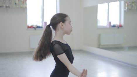 young ballerina practicing dance moves in studio