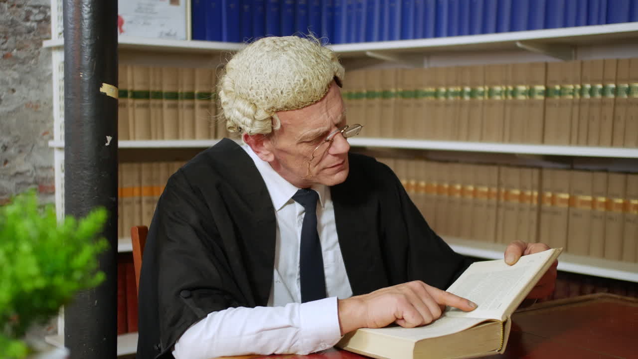 A judge or barrister reading in a law library with wig and gown