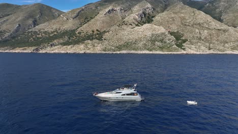aerial pullback yacht anchored beautiful mountainous albanian coast