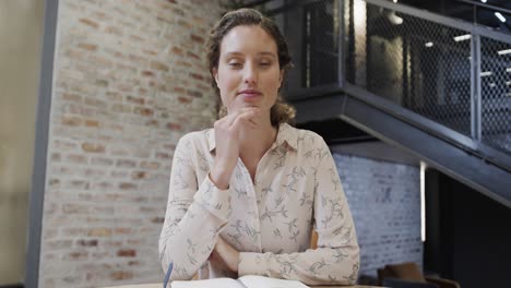 caucasian casual businesswoman making video call in office lounge, slow motion