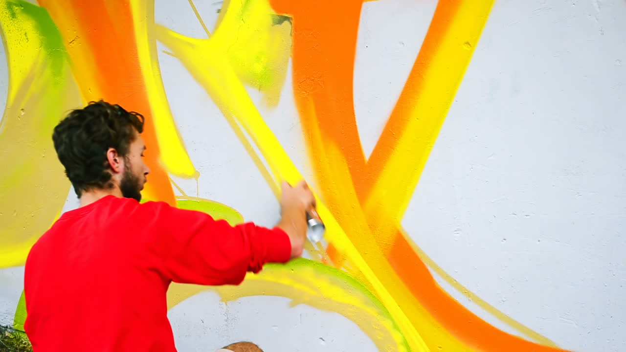 L'artista realizza graffiti su una recinzione. Disegno astratto