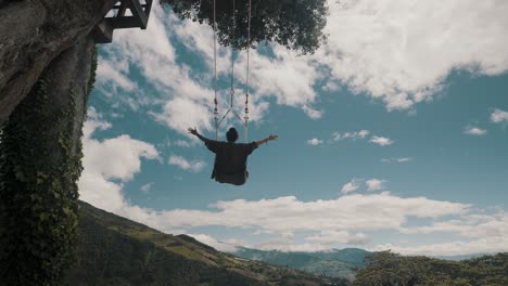 A-Tourist-Riding-The-Famous-Swing-At-The-End-Of-The-World-During-Summertime-In-Banos,-Ecuador