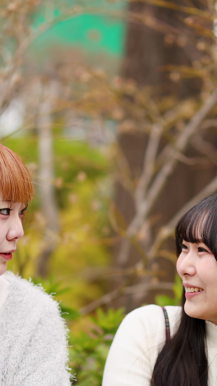 Due donne asiatiche eleganti ridono e parlano all'aperto ad Harajuku, Tokyo, in autunno