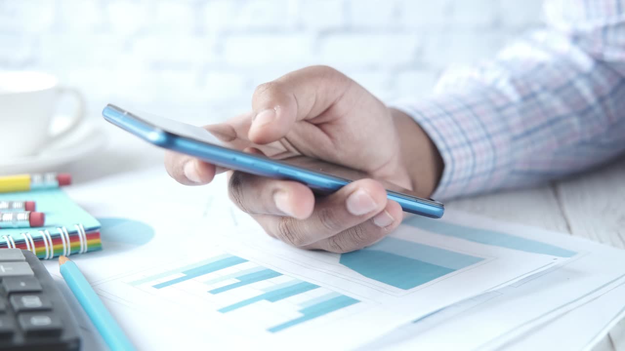 persona que utiliza un teléfono inteligente en un entorno de oficina