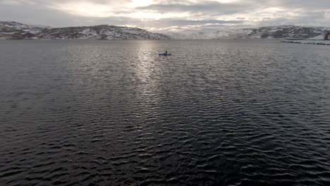 Silhouette-of-man-exercising-in-kayak-on-stormy-overcast-day