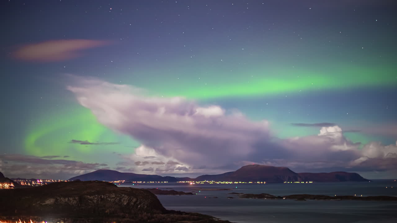 la aurora boreal, las estrellas y un paisaje nuboso dinámico sobre alesund, las islas de noruega y el puerto marítimo - lapso de tiempo