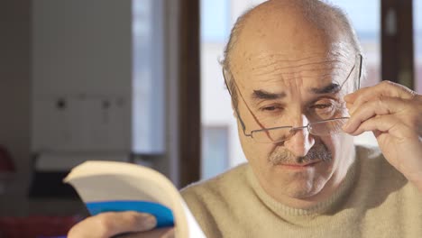 old man reading historical book is surprised and amazed.