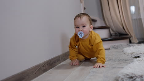 baby crawling on floor with pacifier