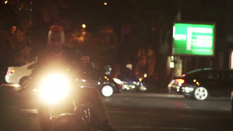 stylish, brutal motorcyclist drives a bike in the city with bright headlight by street road