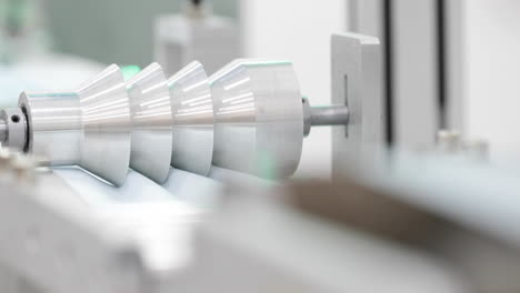 modern machinery with tool makes pleats on fabric to manufacture medical masks - protection for covid19 - close up, slow motion