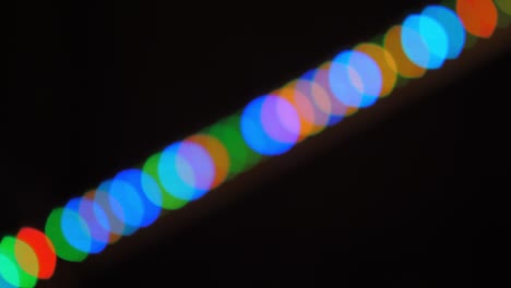 bokeh shot of defocused blurred christmas tree light that is blinking on black
