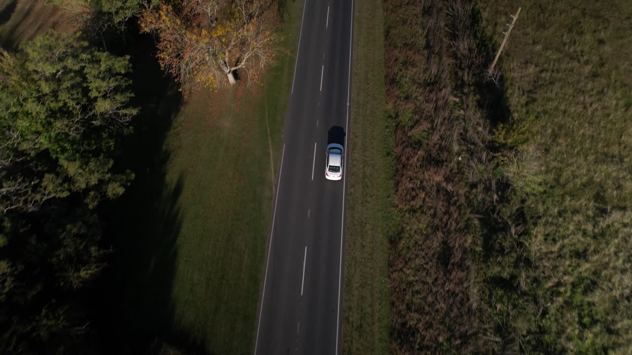 vista aérea superior de seguimiento de un coche en una carretera recta, argentina