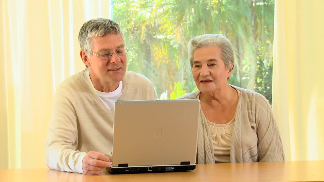 pareja de ancianos usando una computadora portátil