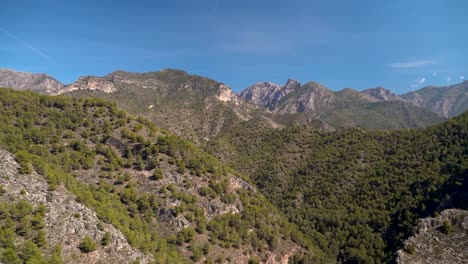 Pan-A-Través-De-Hermosos-Picos-De-Montaña-Verdes-Contra-El-Cielo-Azul-En-Un-Paisaje-árido