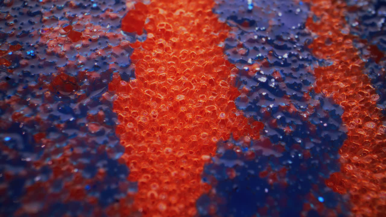 Close-up of a textured sponge with orange and blue stripes