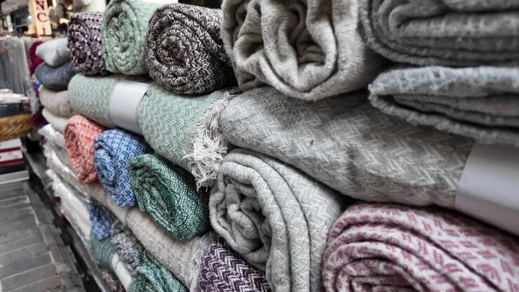 Coperte e Plaid Arrotolati Colorati Impilati in Esposizione