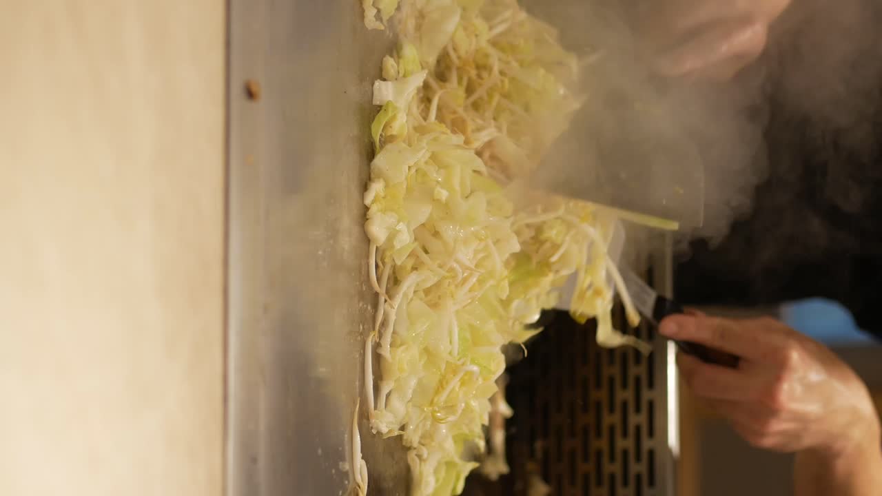 Cooking cabbage and bean sprouts on a griddle