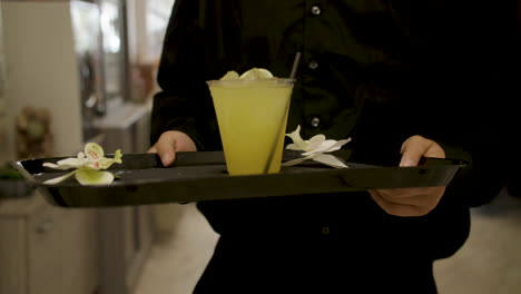 server carrying yellow mixed alcoholic drink
