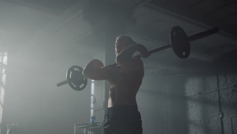 male bodybuilder performing front squats with barbell. man lifting weights